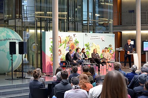 Podiumsdiskussion in großem Konferenzraum.
