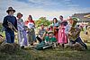 Männer und Frauen in Trachten posieren mit Musikinstrumenten