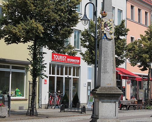 Blick auf die Postmeilensäule in Bad Liebenwerda, im Hintergrund die Tourist-Info.
