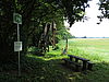 Kleiner Aussichtspunkt am Feldrain bei schönem Wetter mit Aussicht auf ein grünes Feld.