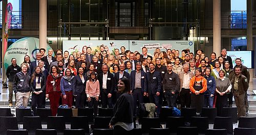 Menschen in einem großen Konferenzsaal für ein Gruppenfoto.
