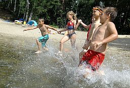 Kinder rennen ins Wasser im Waldbad Zeischa