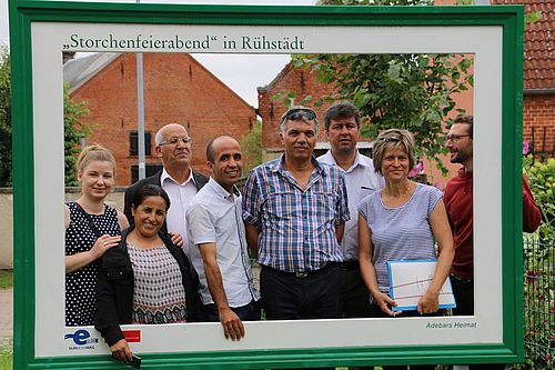 Die Besuchergruppe steht in einem großen Rahmen, der als Postkartenfotomotiv wirkt.